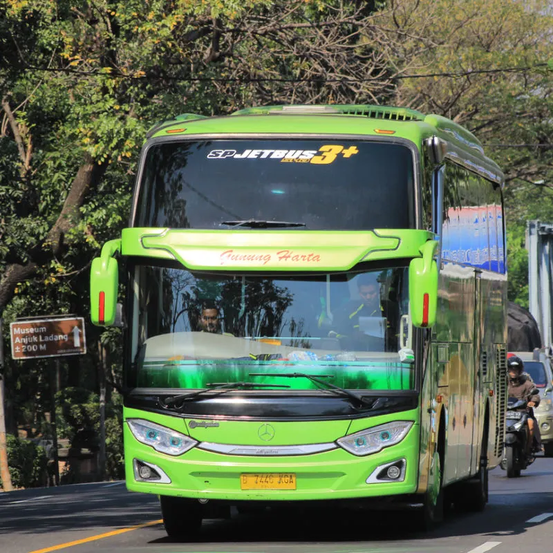 Green Bus Drives Through Central Bali