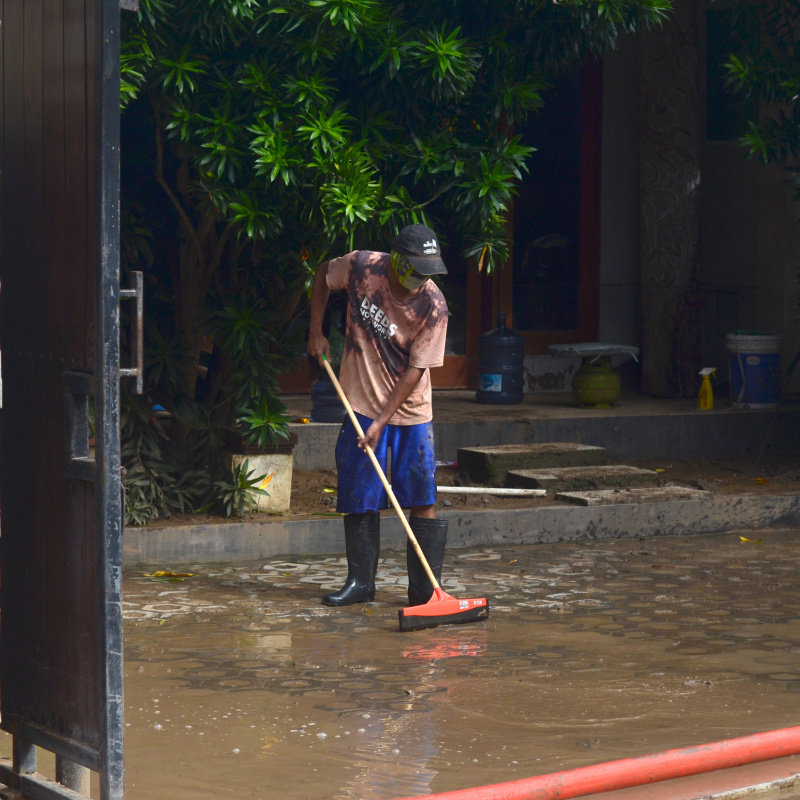 Indonesian Man Tries To Clear Up After Flood Diasater In Bali