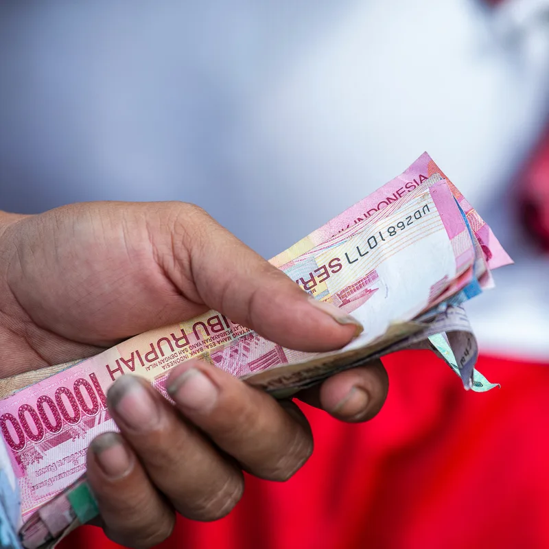 Indonesian Rupiah Cash Money In Someone's Hand.