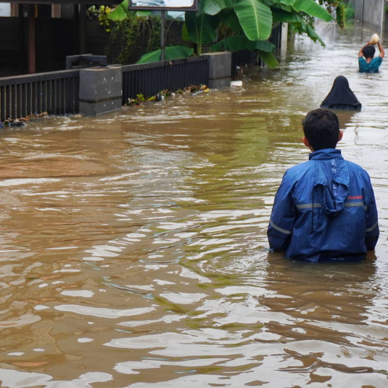 People Wade Through Flood Water In Indonesian Village.