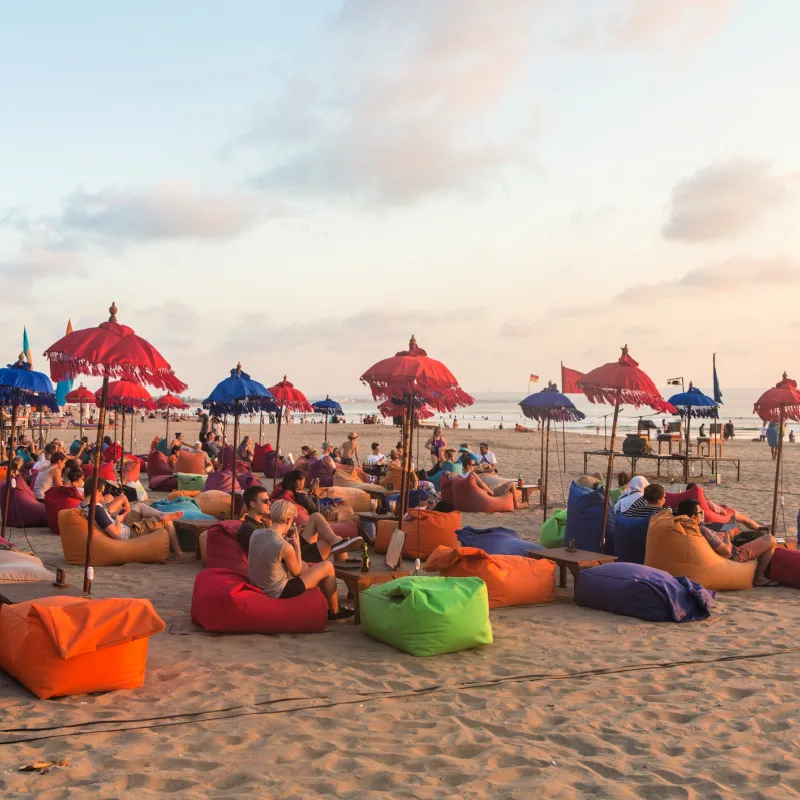 Tourists-Relax-On-Bali-Beach-At-Sunset-