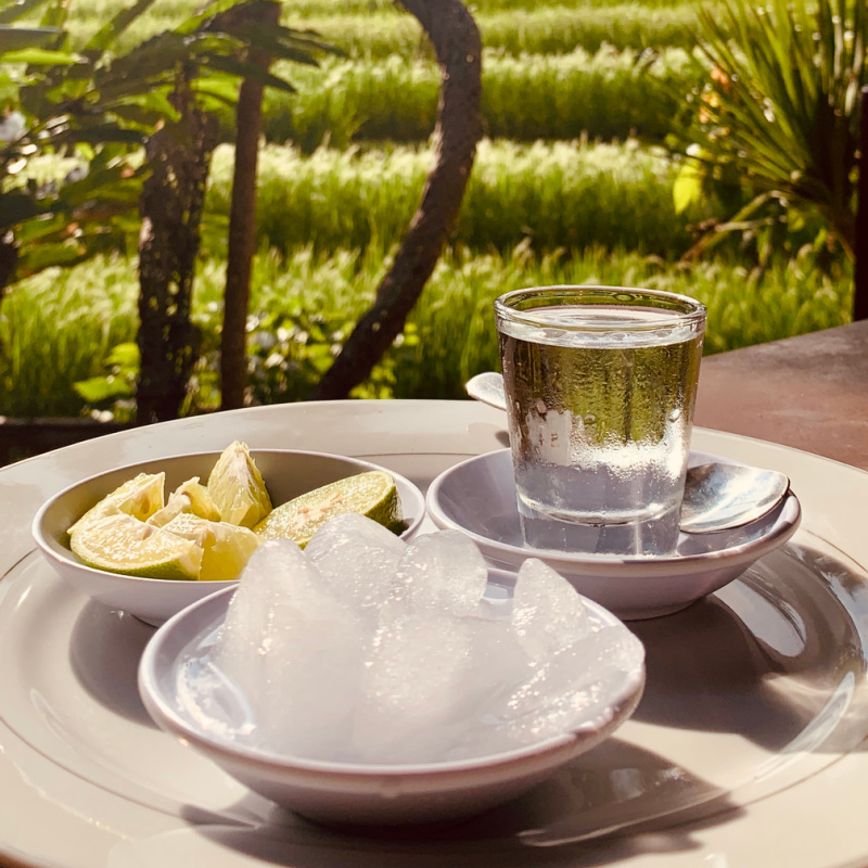 Traditional Bali Arak In A Class With Ice And Lime Overlooking Rice Field
