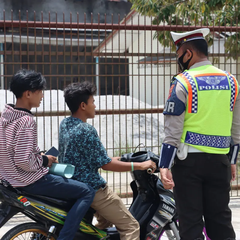 Traffic Police Officer Stops Two Young Men Driving A Moped