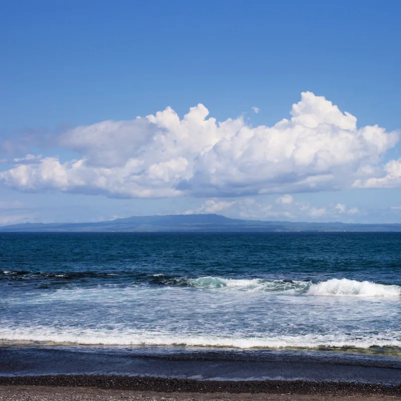 View From Keramas Black Sand Beach In Bali With View Of Nusa Islands In The Distance