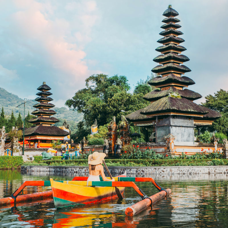 View Of Pura Ulun Danu Beratan Temple in Bali with Person Rowing On Small Traditional Boat