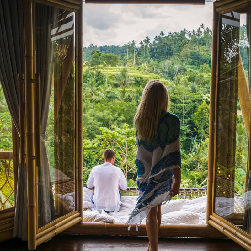 Pareja-en-Bali-hotel-de-lujo-viendo-el-jardín-y-el-bosque
