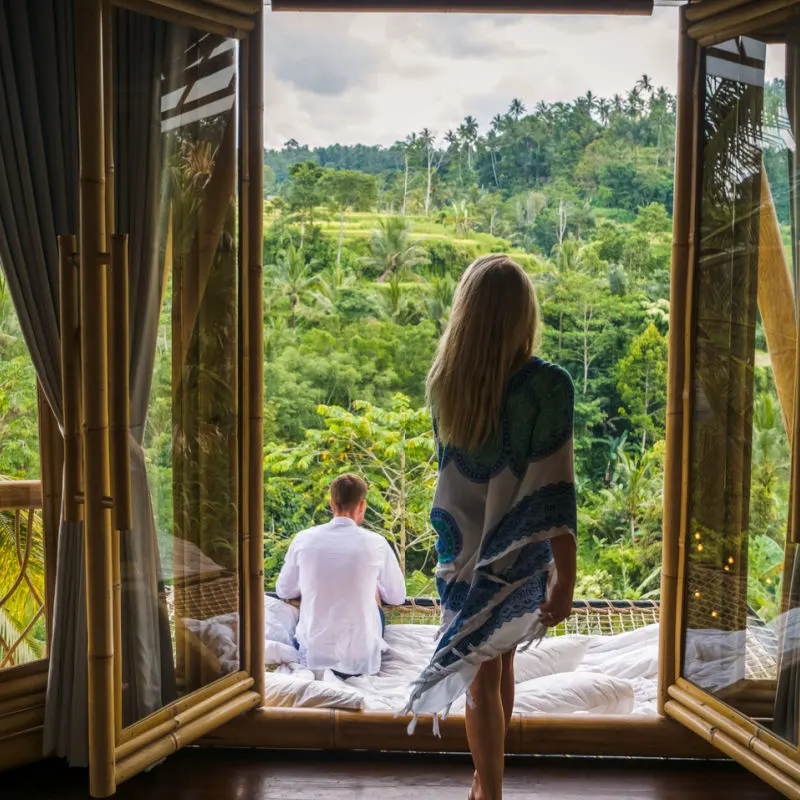 Couple in a luxury hotel in Bali with a view of rice fields and jungle