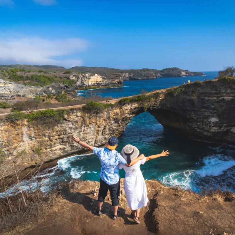 Couple-Look-Out-Over-Broken-Beach-In-Bali-Nusa-Penida