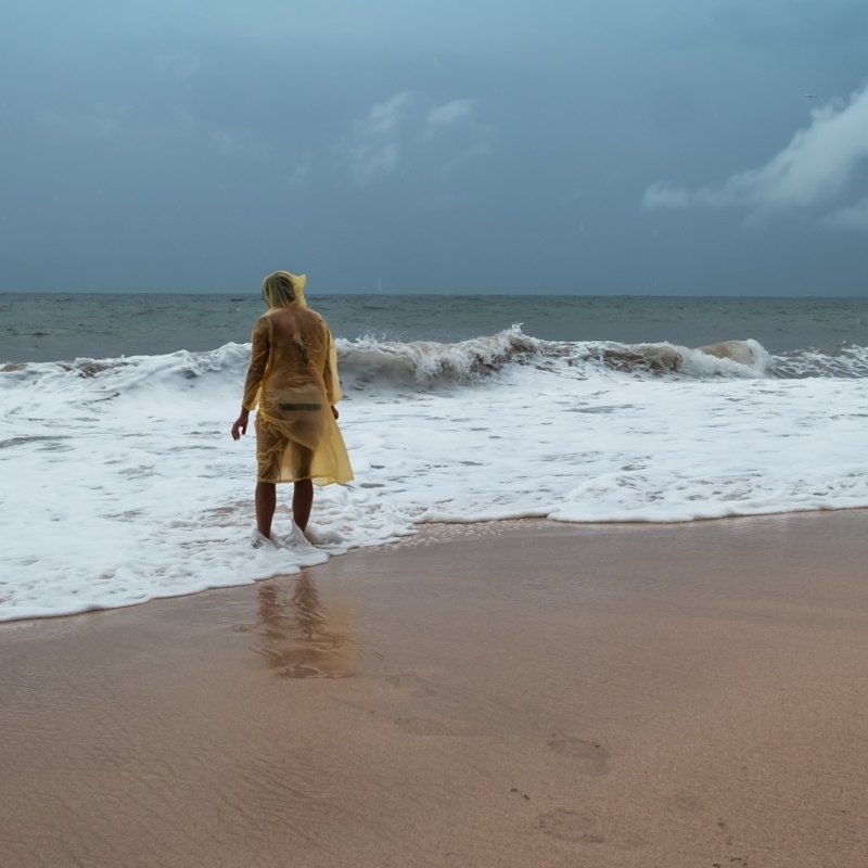Person-Stands-At-Shoreline-on-Empty-Bali-Beach-During-Bad-Weather-Rain-and-Storm
