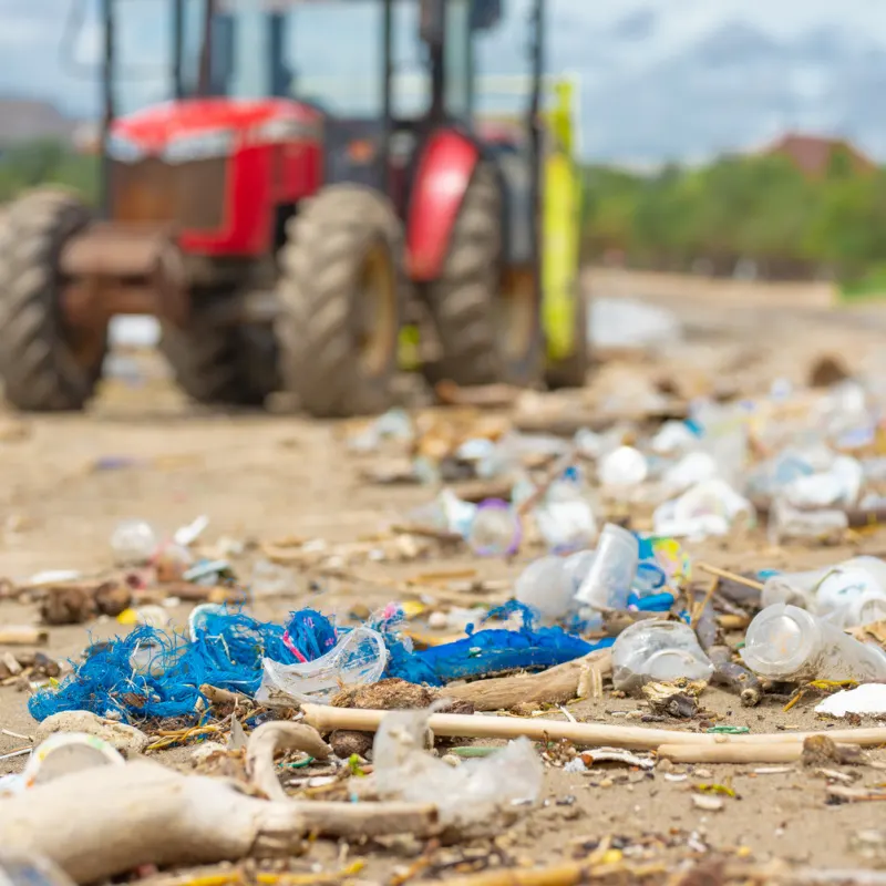 Plastic-Waste-And-Tractor-On-Beach-In-Bali