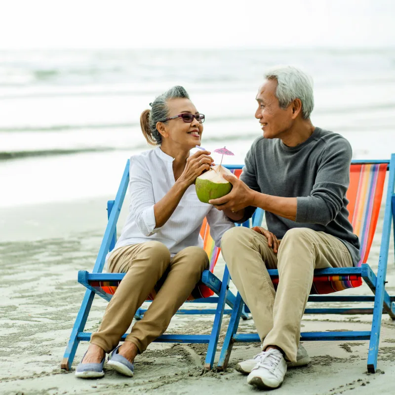 Retired-Old-Couple-On-Deck-Chairs-On-The-Beach