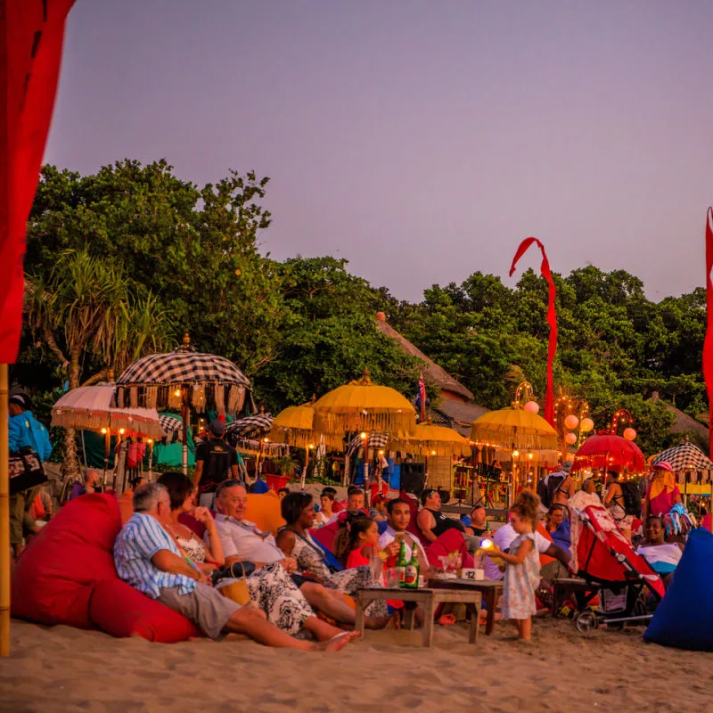 people on a beach in bali drinking and hanging out