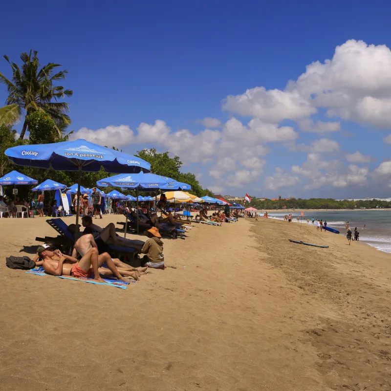 Tourists Sunbathe On Kuta Beach In Bali.