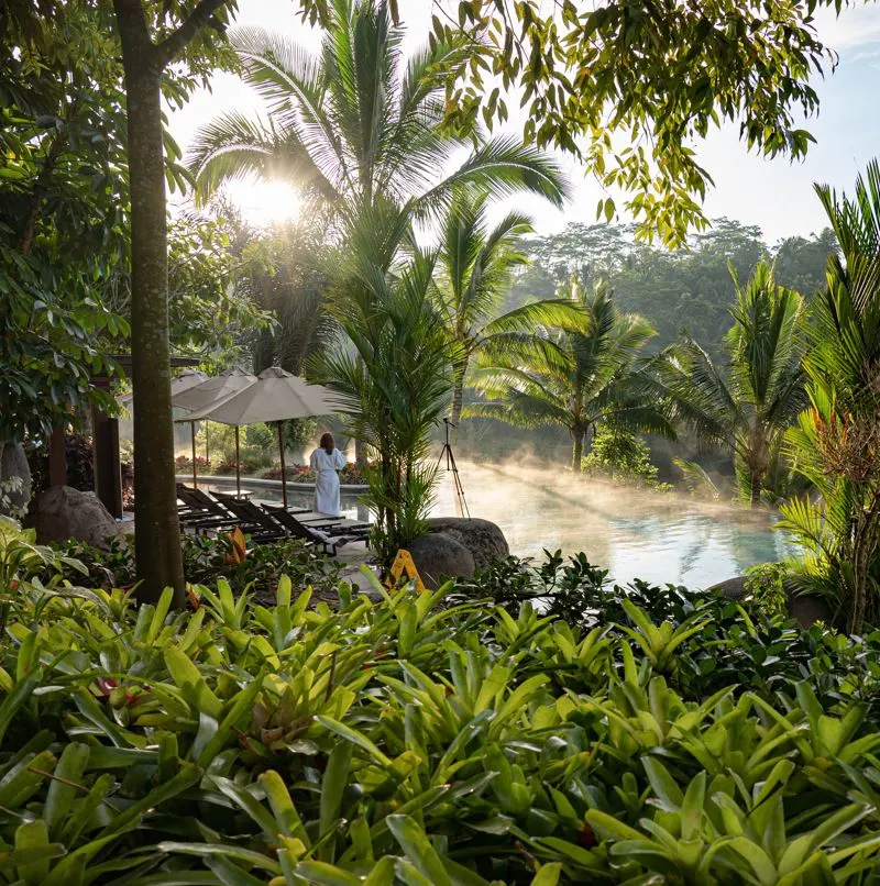 Woman walking through grounds of a hotel in ubud, bali