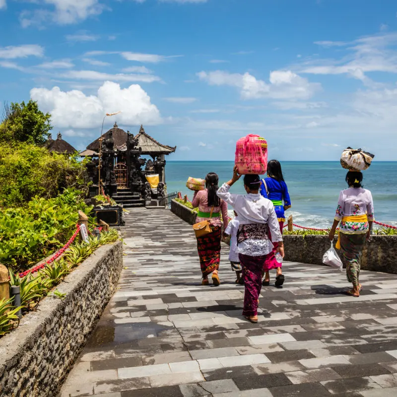 Bali Women Walk Towards Tanah Lot Temple.