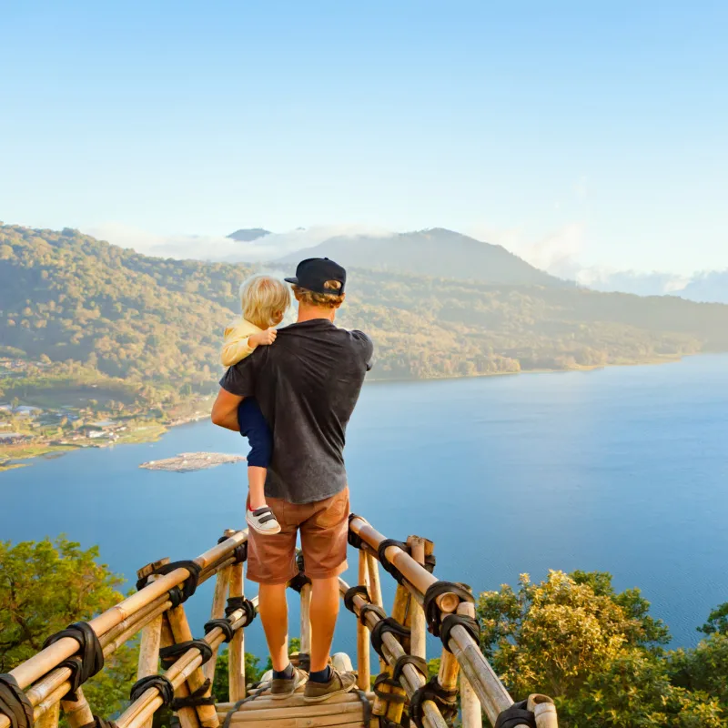 Father Holds Son As Tourists On Bali Family Holiday