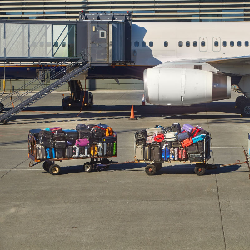 Luggage In Trolleys Waiting To Be Loaded Onto airplane