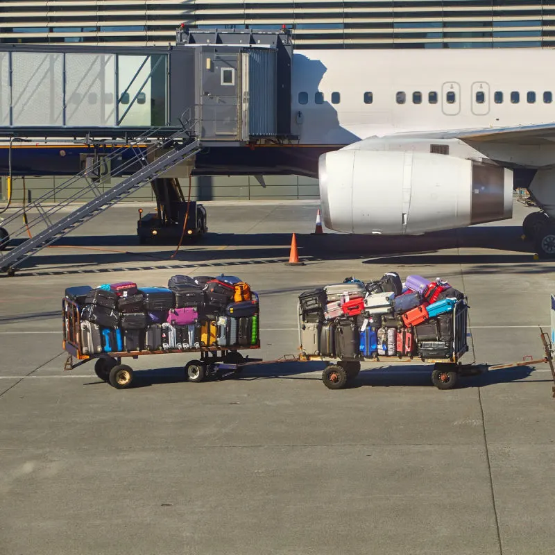 Luggage-In-Trolleys-Waiting-To-Be-Loaded-Onto-airplane