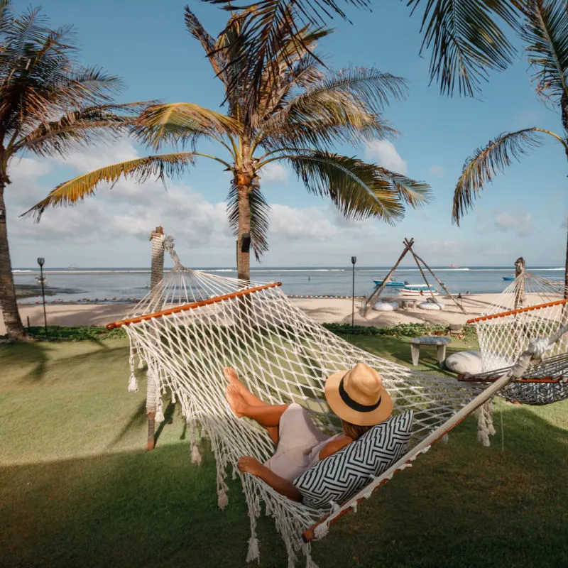 Tourist Relaxes in Hotel In Bali Garden with a Hammock