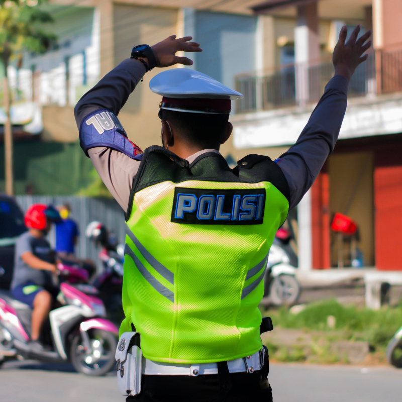 Traffic Police Officer Directs Cars and Moped In Bali
