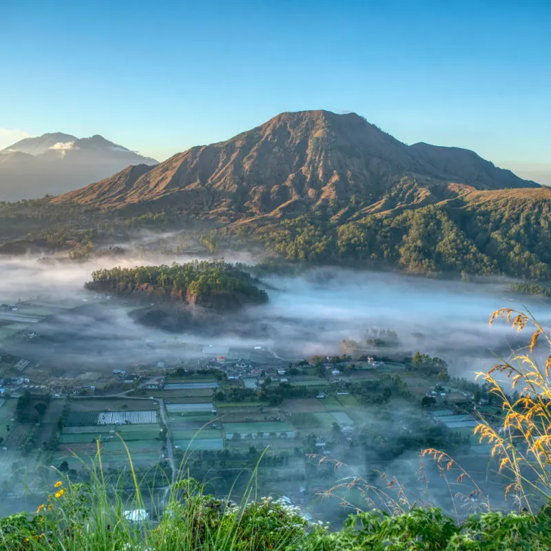 Mount-Batur-Peaks-Up-Above-The-Fog-Over-The-Villages-Below