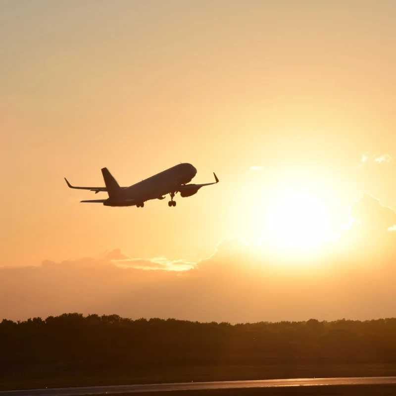 Plane-Takes-Off-Runway-Towards-Sunset