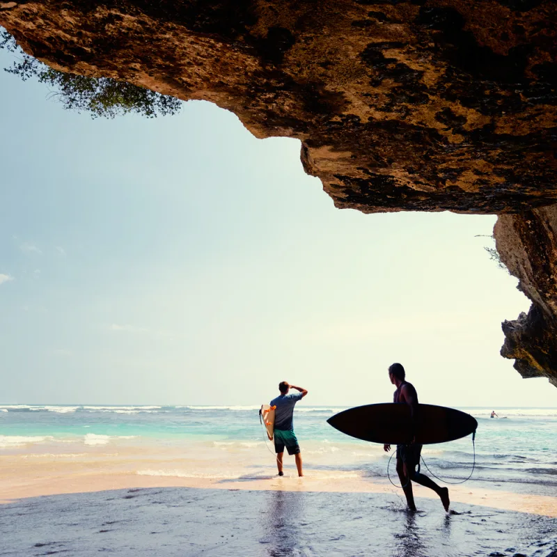 Surfers Walk Out To Waves on Beach in Uluwatu Bali