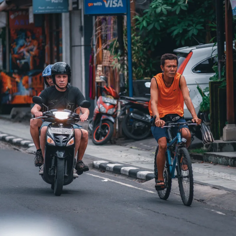 Tourist-Drives-Moped-On-Street-in-Bali