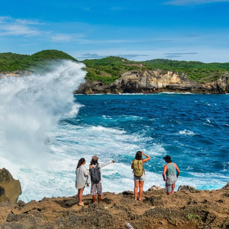 Tourists Stand On Clifftop in Bali