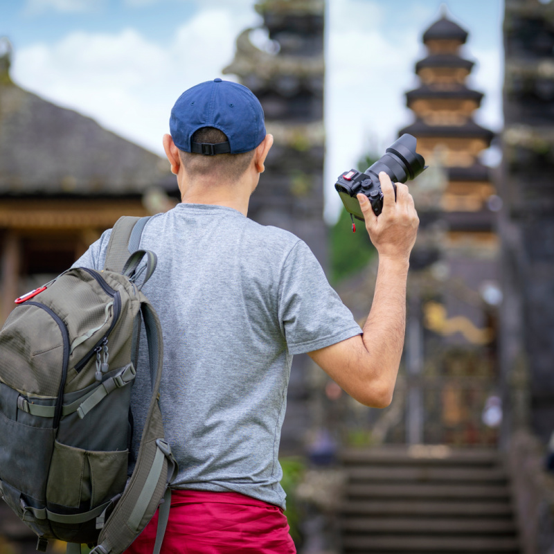 Man-Holds-Camera-Outside-Bali-Temple