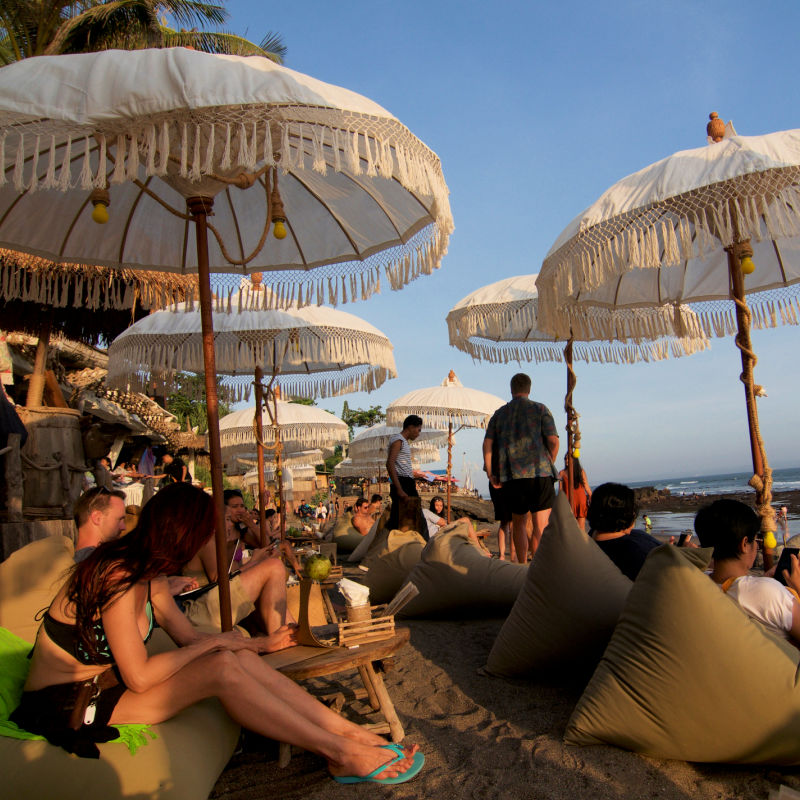Tourists Relax On Beach Under Sun Umbrellas.jpg