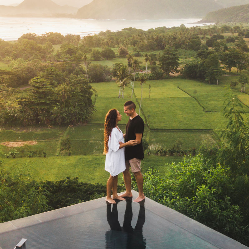 Couple Stand At Edge Of Infinity Pool in Bali .jpg
