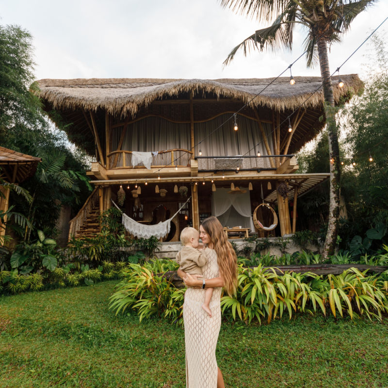 Tourist Woman Stands Outside Airbnb Bamboo House in Bali.jpg