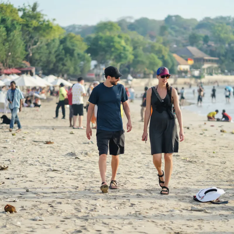 Turis berjalan di pantai Jimbaran.jpg