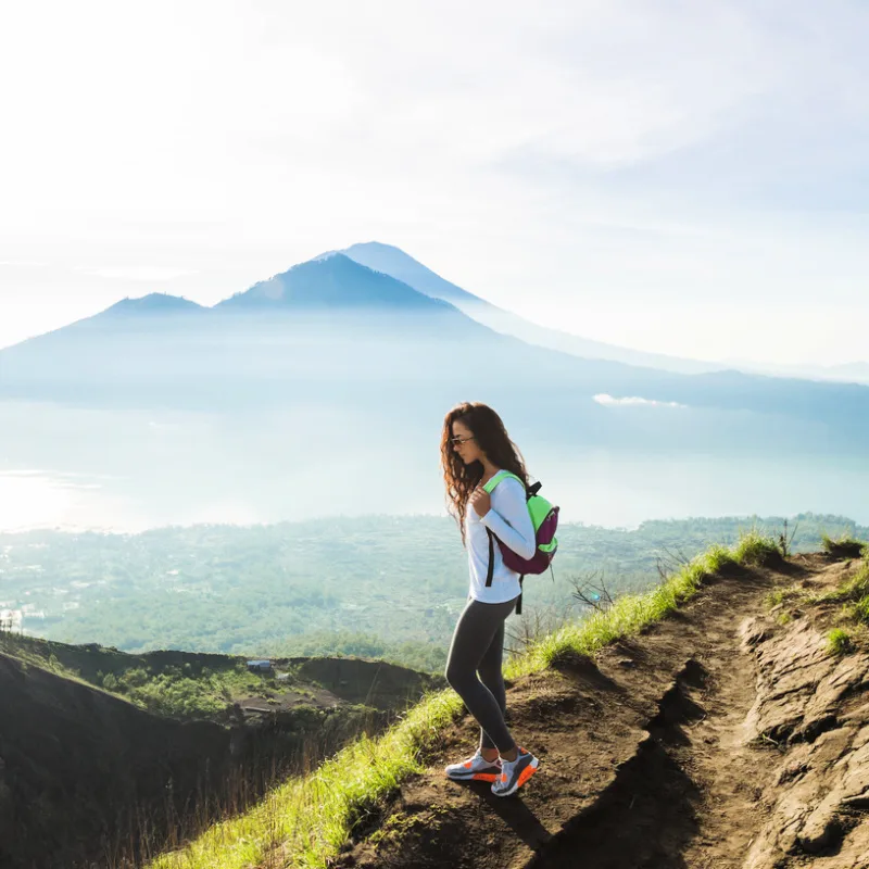 Tourist-On-Hiking-Trail-Mount-Batur-looking-at-Mount-Agung-in-Bali