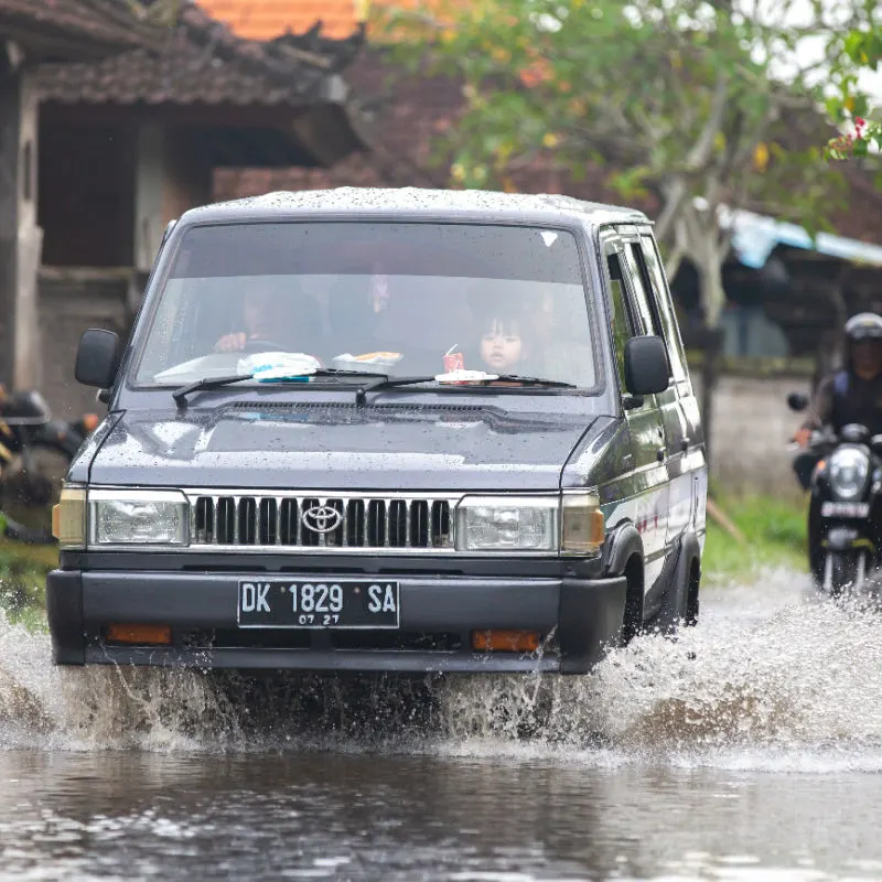 Car-drive-thorugh-flooded-road-in-Bali-village-in-daytime