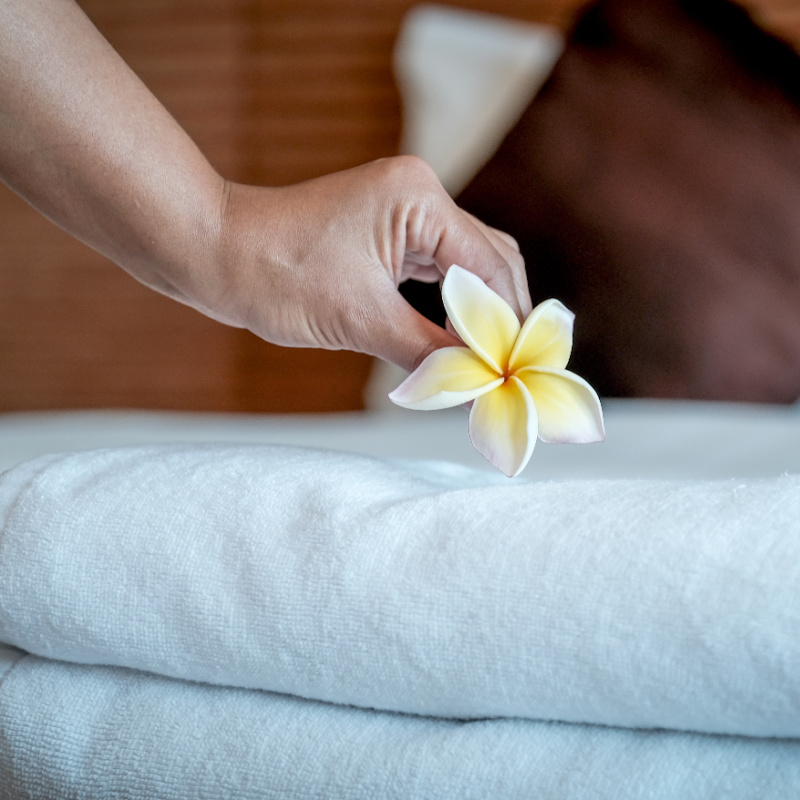 Hotel-maid-puts-flower-on-towels-on-hotel-bed