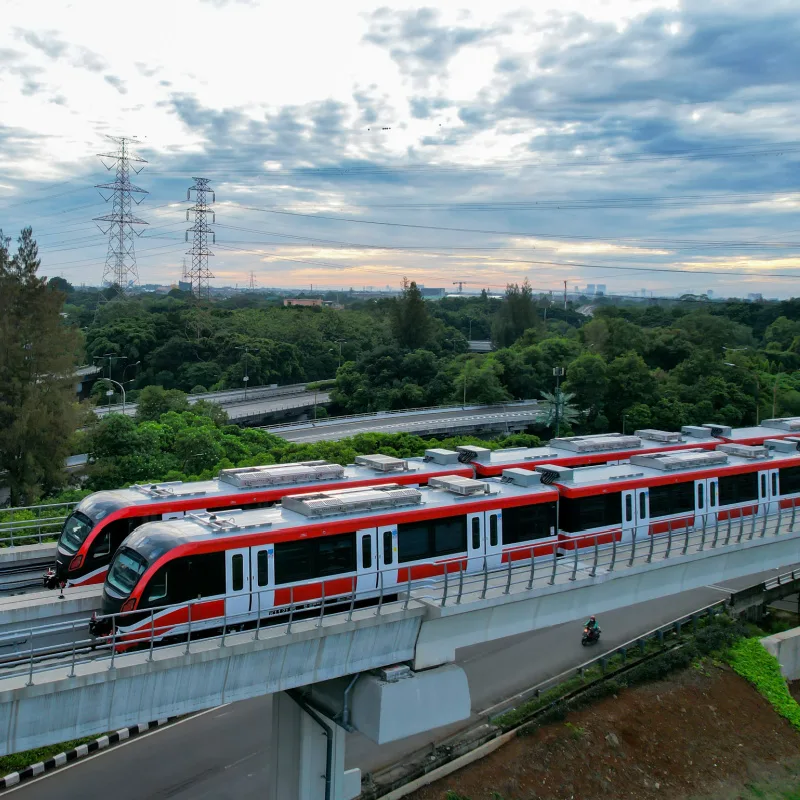 Jakarta Metro Trains By Trees In Daytime.jpg