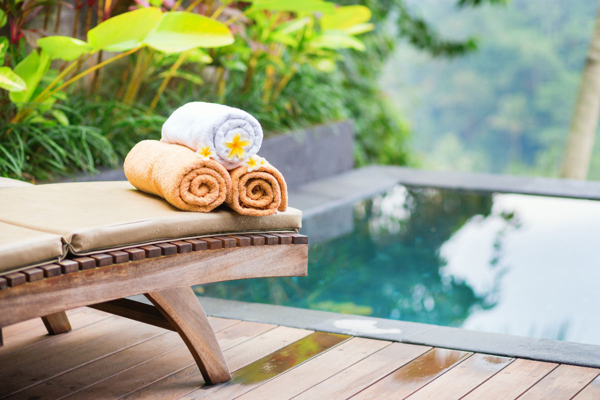 Towels and Frangipani on Sunlounger by Pool at Hotel in Bali.jpg