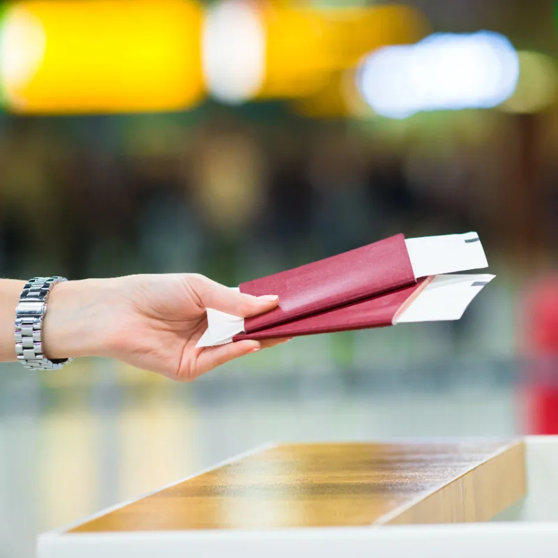 Туристы сдают паспорта на иммиграционной стойке в аэропорту