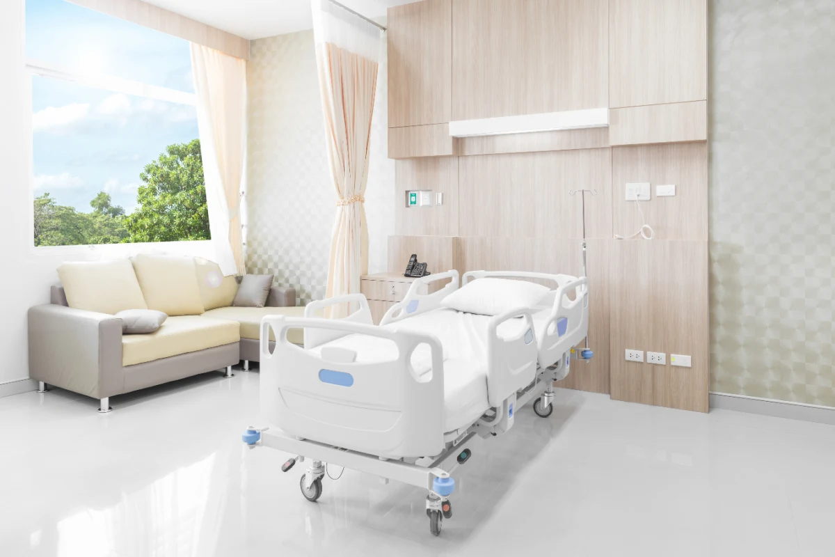 New hosital private room with bed and tree window view.jpg