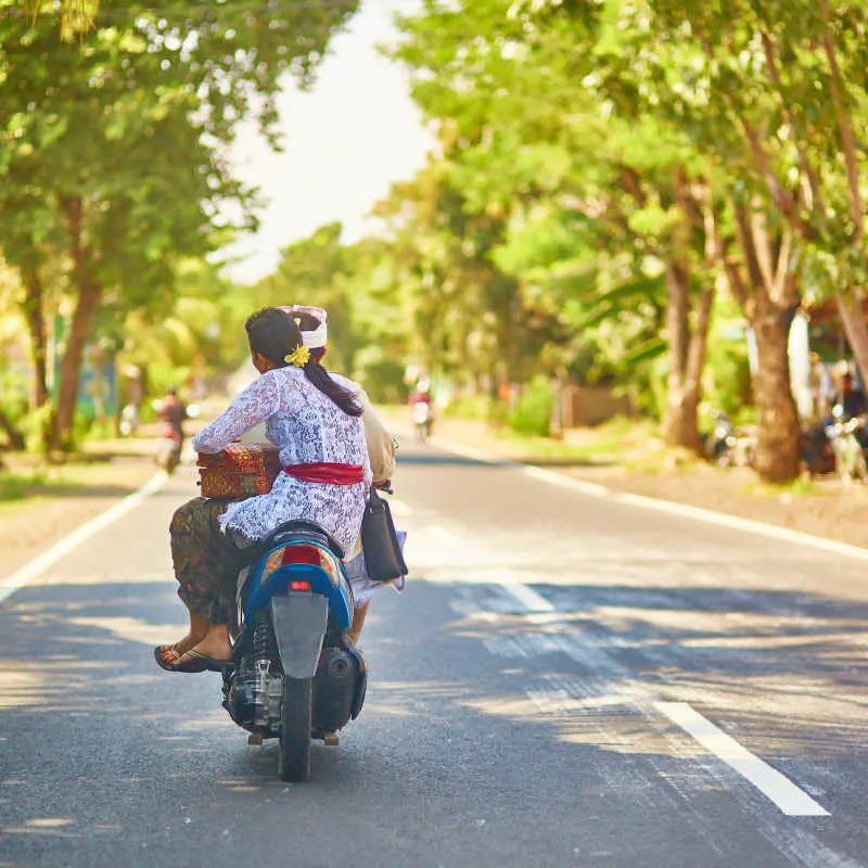Balinese-Couple-Ride-on-moped-on-Bali-road-in-daytime