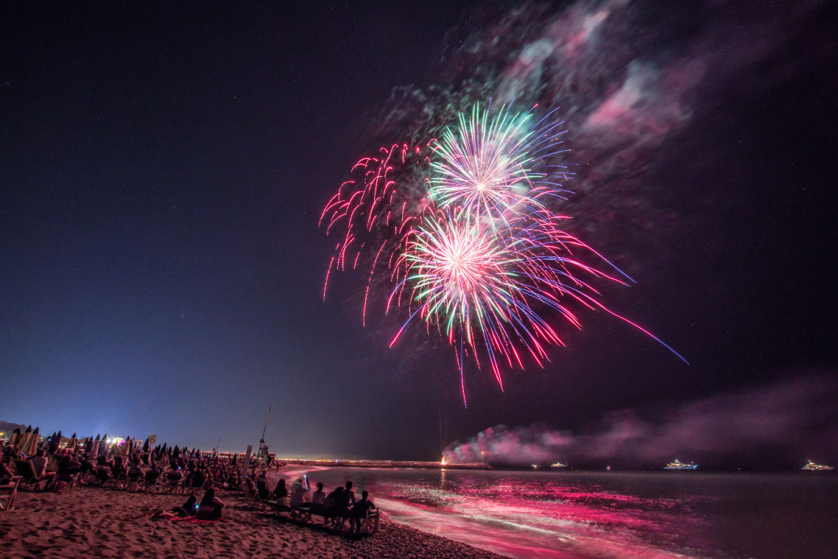 Fireworks over the ocean and beach with crowd watching.jpg