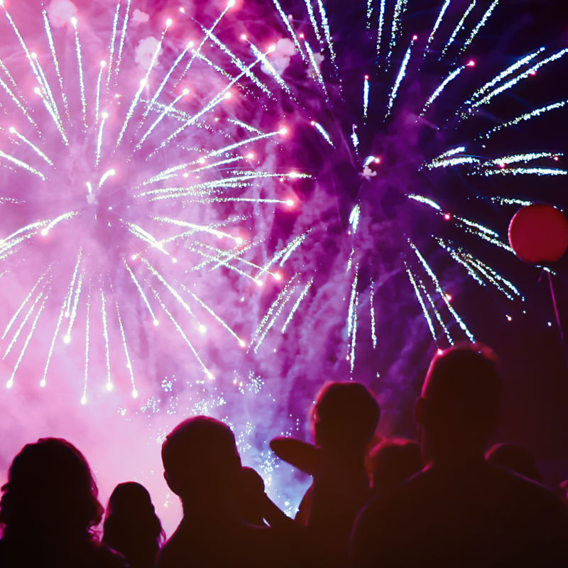 Families-watch-pink-fireworks-display-at-nighttime