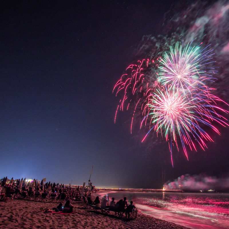 Fireworks-over-the-ocean-and-beach-with-crowd-watching