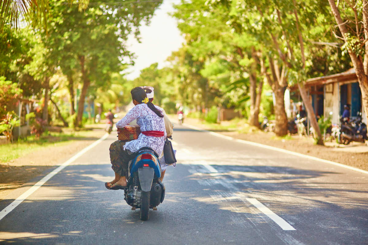 Balinese Couple Ride on moped on Bali road in daytime.jpg