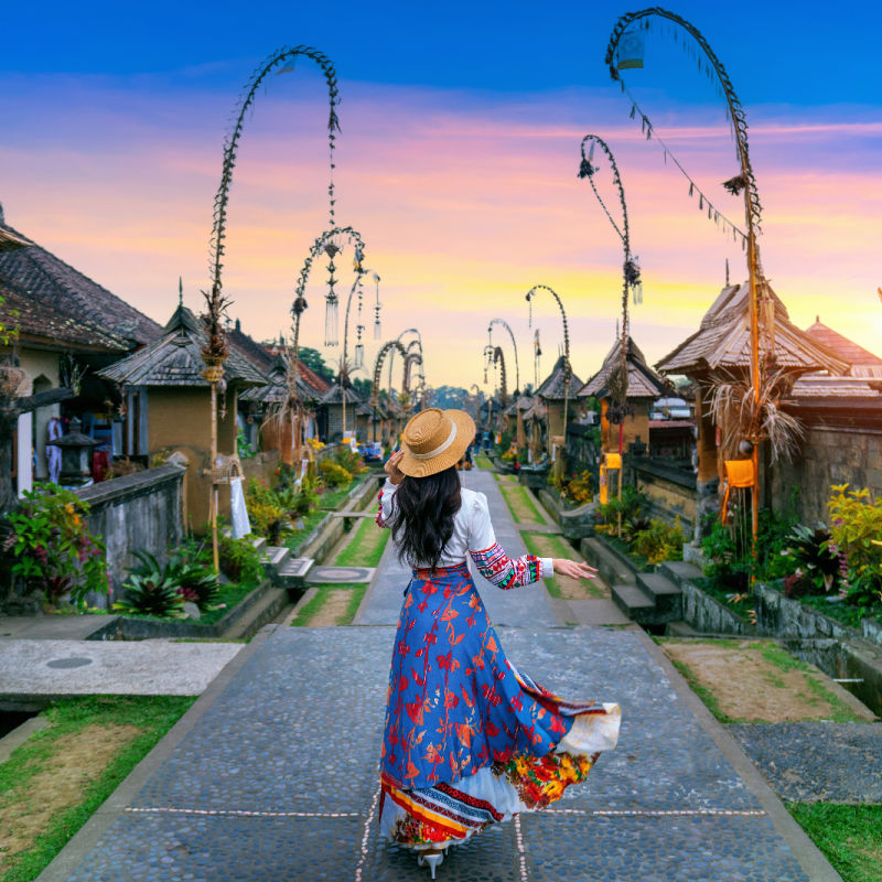 Woman-walks-through-Penglipuran-Village-at-sunset-in-Bali