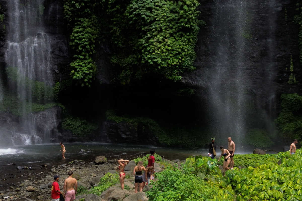 Turyści zwiedzają wodospady Segumbul w Puleleng Regency.jpg