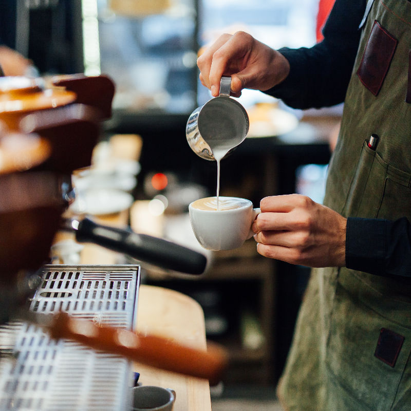 Barista-pours-coffee-in-cafe