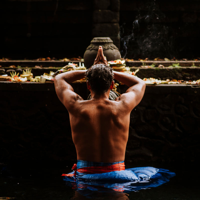Man-takes-part-in-Melukat-ceremony-at-Tirta-Empul-Temple-in-Bali